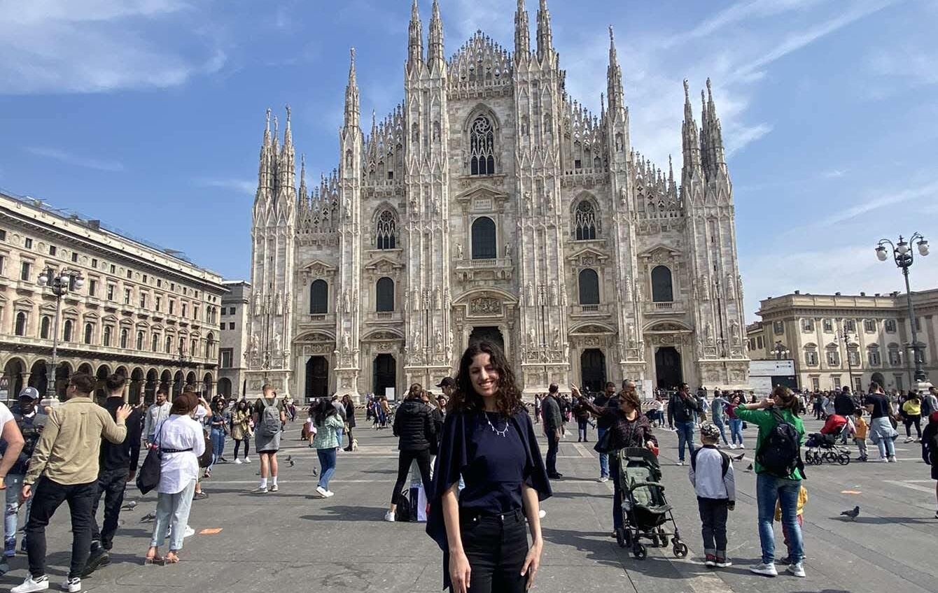 female Butler student in dark clothes in front of cathedral in Milan