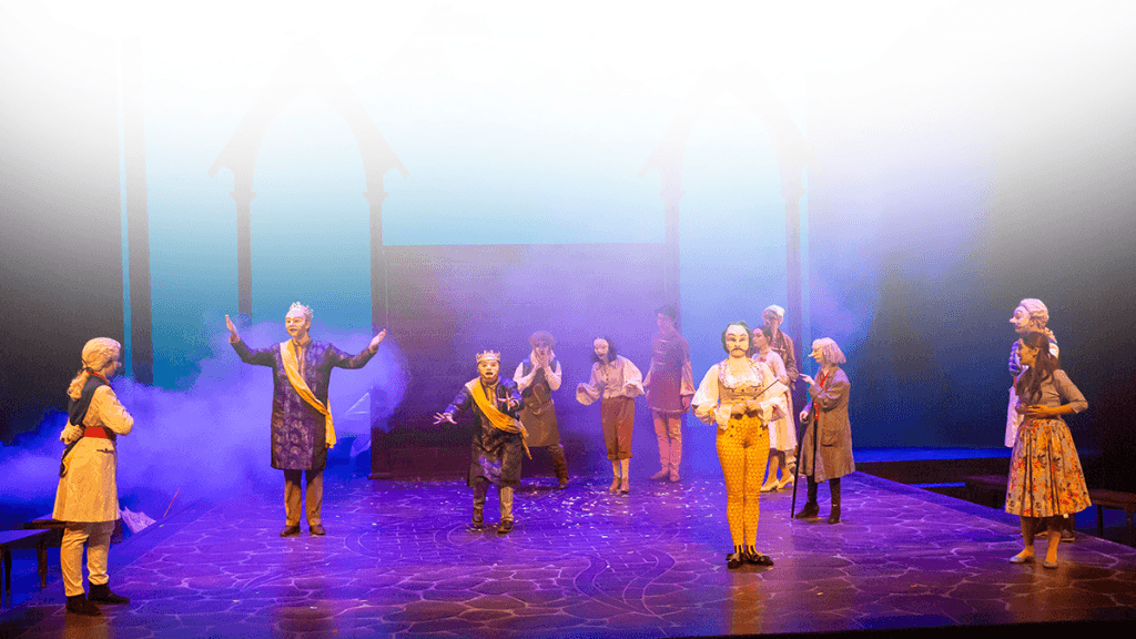 multiple costumed performers on stage with masks on