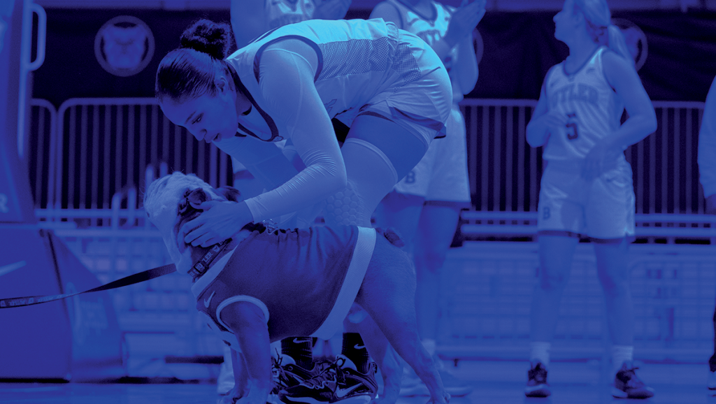 blue screen over female basketball player in white uniform petting Butler Blue IV