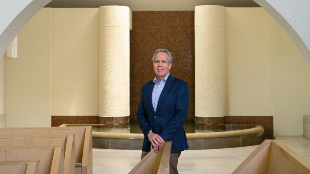 President James Danko wearing a navy blue blazer and standing inside Sweeney Chapel on Butler's South Campus.