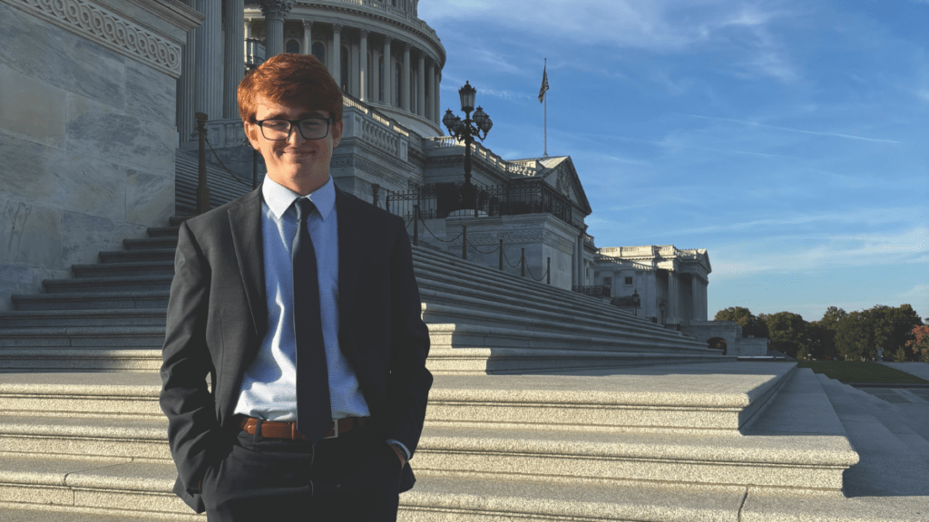 Brady Stinson in a suit standing in front of the U.S. Capitol.