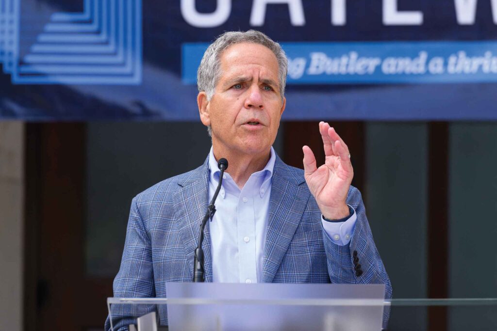 Butler University President James Danko speaks at podium beside Ross Hall talking about the Butler Gateway Project.