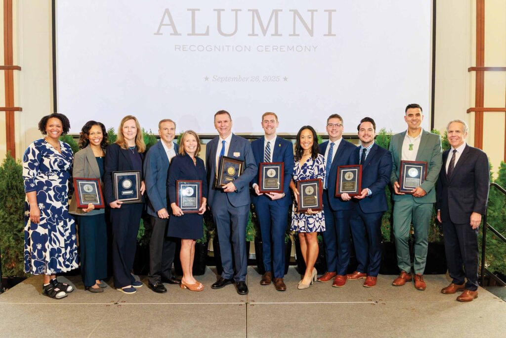 Butler alumni smile and hold their award plaques at the 2025 alumni awards ceremony.