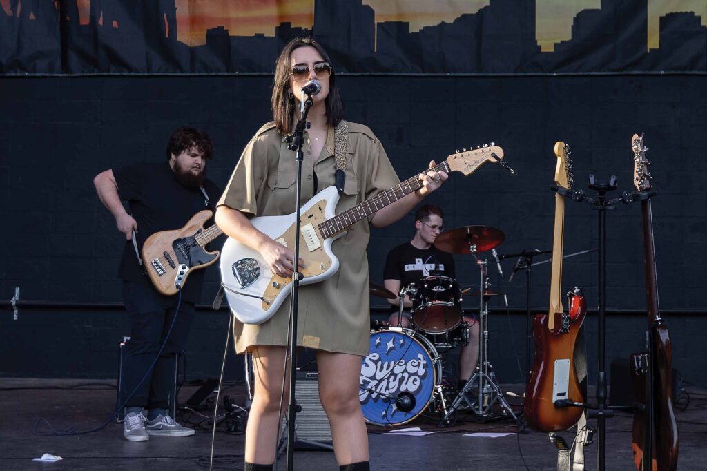 Annie Brown sings and plays guitar on stage with her band.