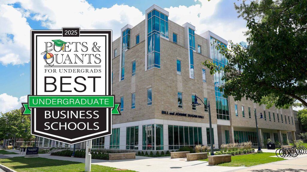Butler's Dugan Hall, with its limestone and glass facades, on a sunny summer's day. A graphic from Poets & Quants for Undergrads states "Best Undergraduate Business Schools" in front.