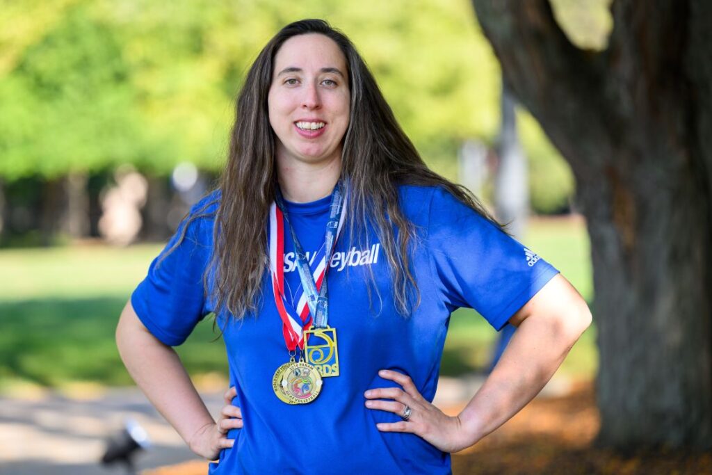 Kelly Kidd in a blue shirt with gold Olympic medals around her neck
