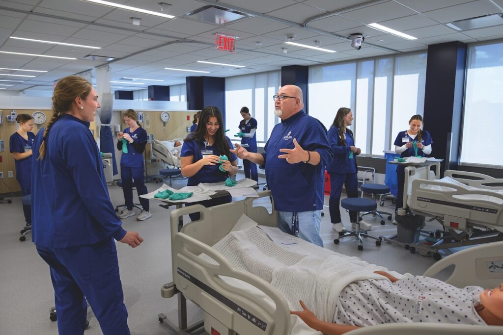 Image of Butler University nursing students with professor in medical classroom lab