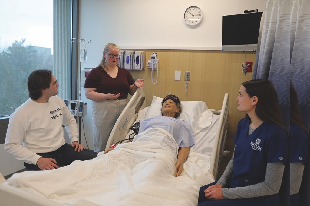 Image of Butler University students in a medical classroom lab with a test patient
