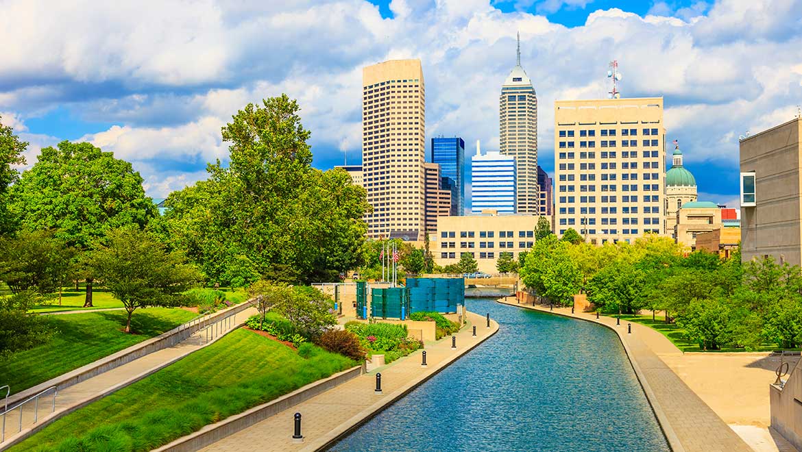 aerial view of the indianapolis canal with skyline of indianapolis behind it