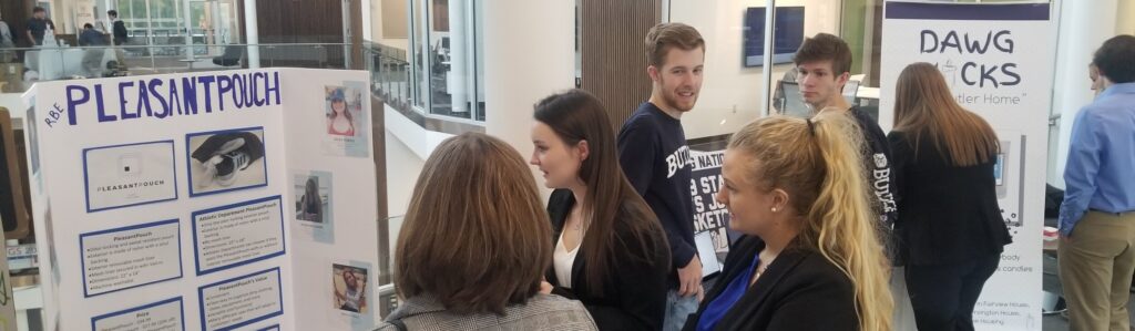 Visitors viewing a student's presentation at an RBE Tradeshow