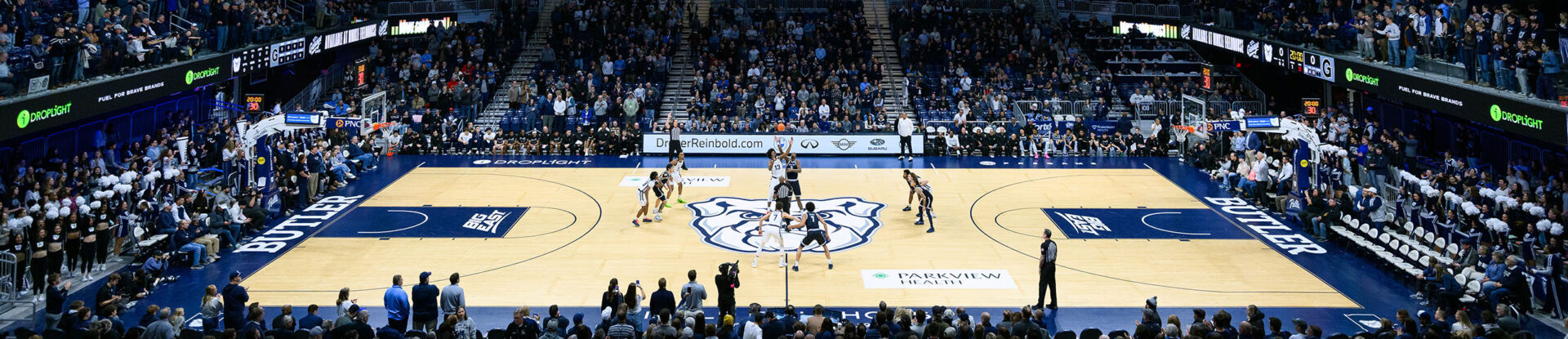 Crowd cheers for tipoff of basketball game inside Hinkle Fieldhouse.