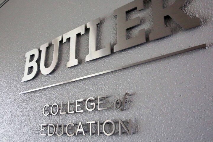Butler College of Education sign letters shine on a wall.