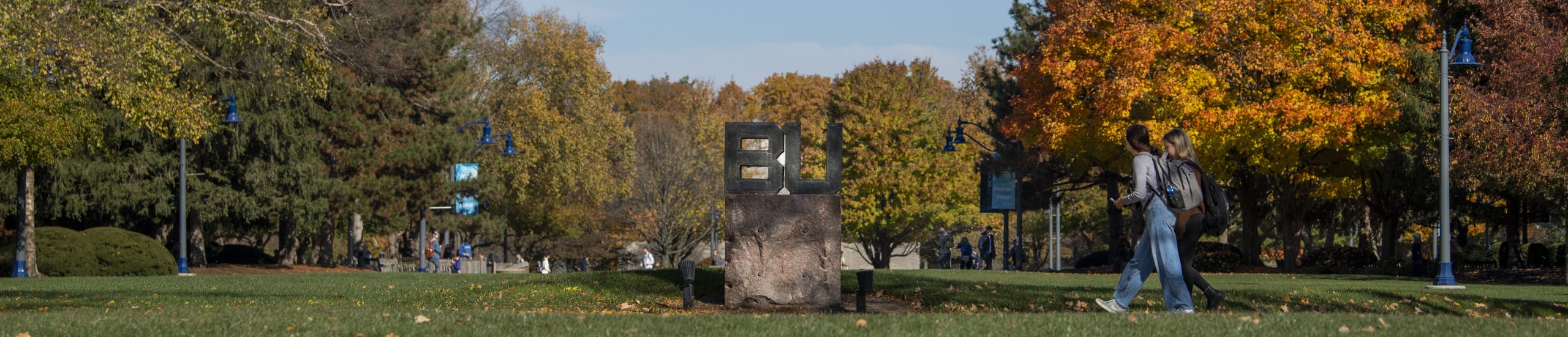 students walking by the BU sign