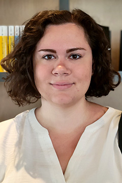 Melissa Evans smiling by bookshelf