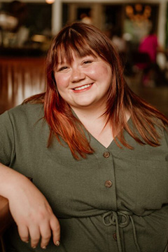 Shelby Jo Reichle smiling in relaxed restaurant environment.