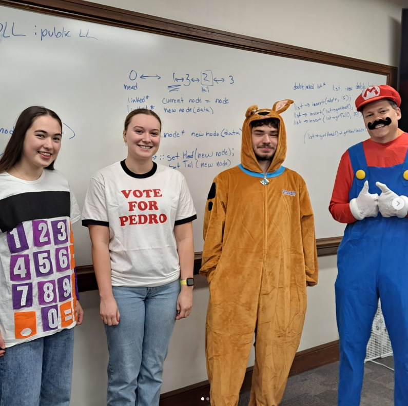 Three students and Prof. Rybarczyk in Halloween costumes