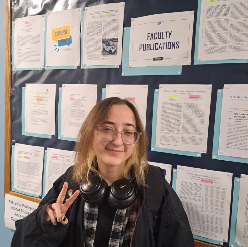 Anna Vadella, pictured in front of the faculty brag board
