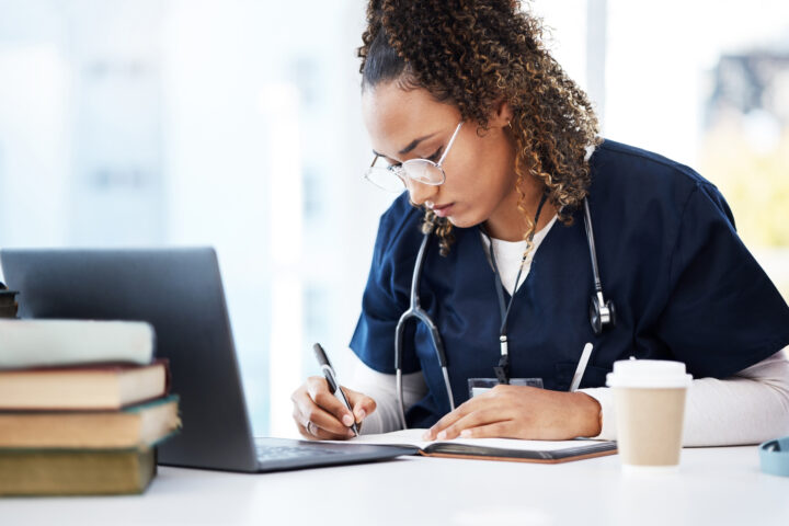 Nursing student, thinking or writing books in research education, wellness studying or hospital learning. Laptop, nurse or healthcare woman and notebook, technology or scholarship medicine internship