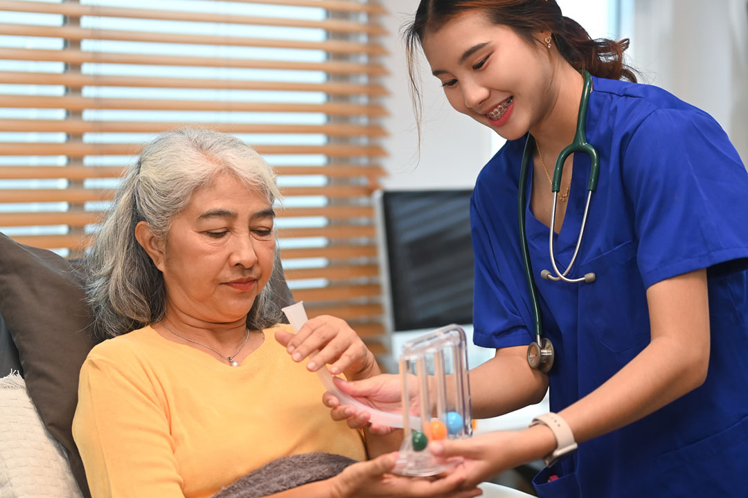 Physical therapist uses incentive spirometer or triflow to help patient to improve functioning of her lungs.