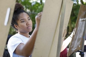 student painting on a canvas