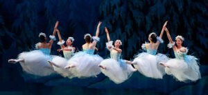 Ballerinas performing on stage mid grand jeté