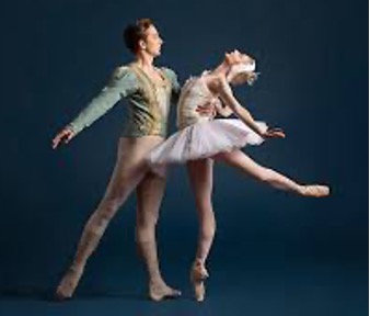 Male ballet dancer holds female ballet dancer by the waist