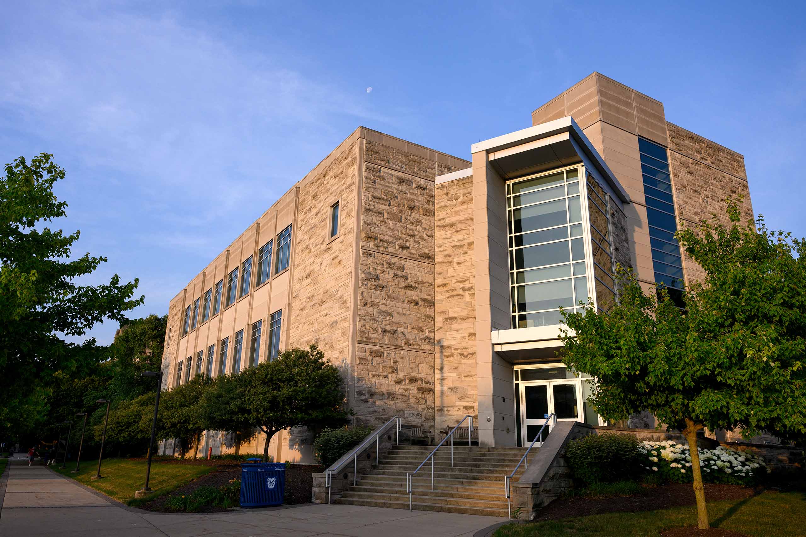 Butler Pharmacy and Health Sciences limestone exterior and main entrance bask in the light of a warm sunrise.