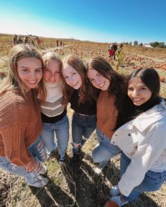 5 members at a pumpkin patch in the fall