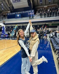 2 member in Theta holding hands in Hinkle Fieldhouse