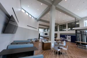 Photo of the interior of a building with couches, tables, and TVs