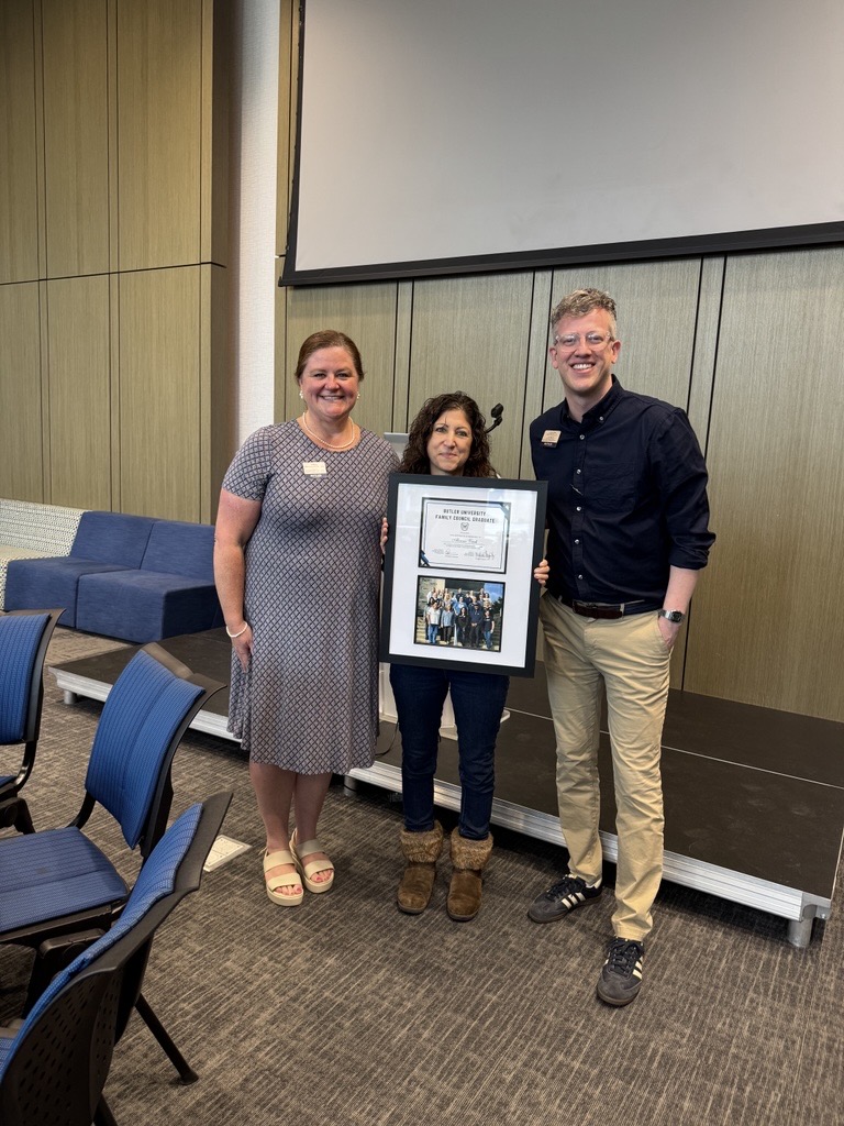 Graduating family member poses with certificate