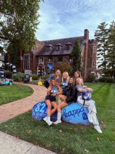 6 sorority women on rock outside of house