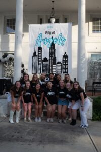 Group of women under "City of Angels" banner from bid day