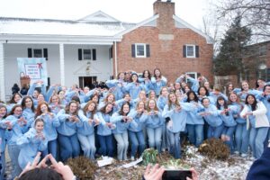 Group of women outside of house with AXO sign