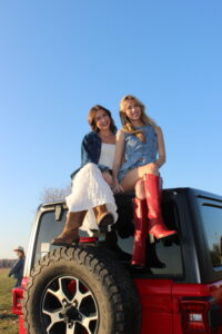 2 women sitting on jeep