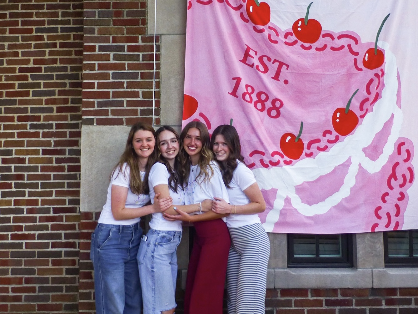 Sisters hugging in front of banner