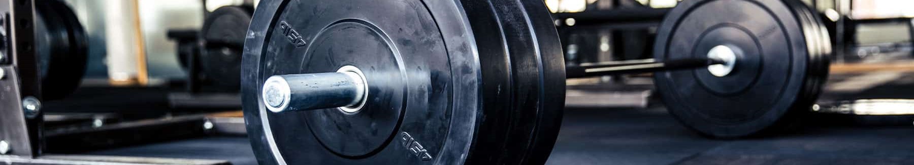 This is a photo of a bar bell weight sitting on the ground in the gym.