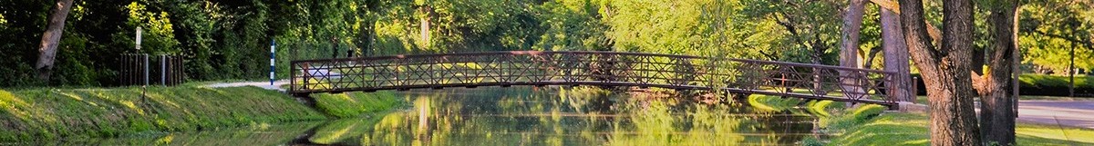 This is a photo of the west side canal and Holcomb Gardens. You can see the bridge crossing the water. 