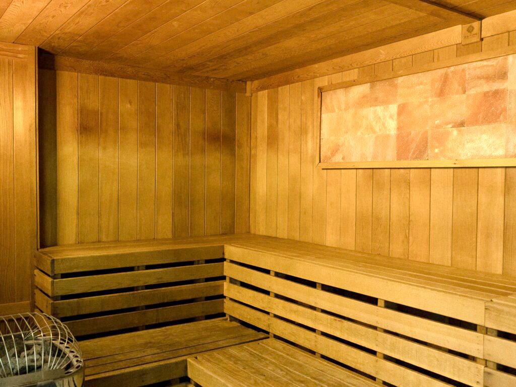 Sauna sitting area with wood panels for ceiling, walls, bench, and floor.