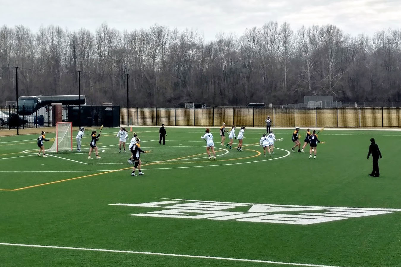College students play lacrosse on large field with other West Campus sports fields nearby.