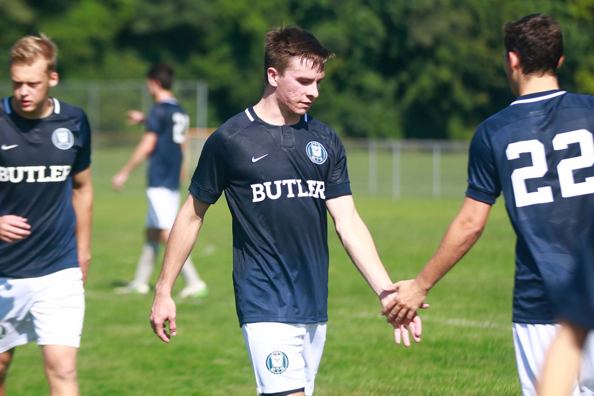 Butler soccer players slap hands in encouragement.