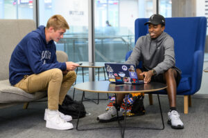 Two Butler University students sitting at a table with a laptop