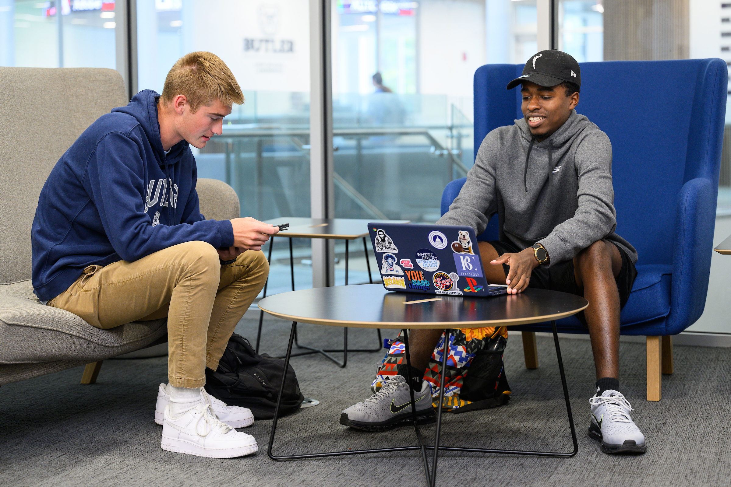 Two Butler University students sitting at a table with a laptop