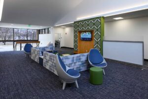 Seating options like couches and chairs in a large, bright, open interior space known as Founder's College Commons.
