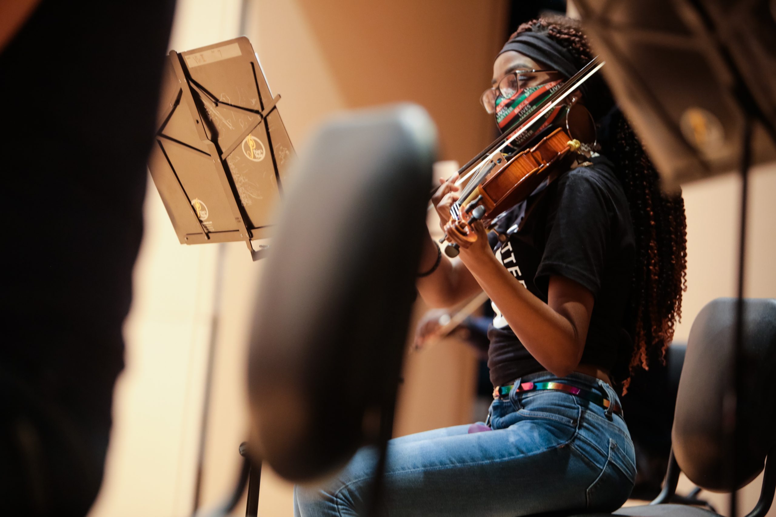 student in a mask playing the violin