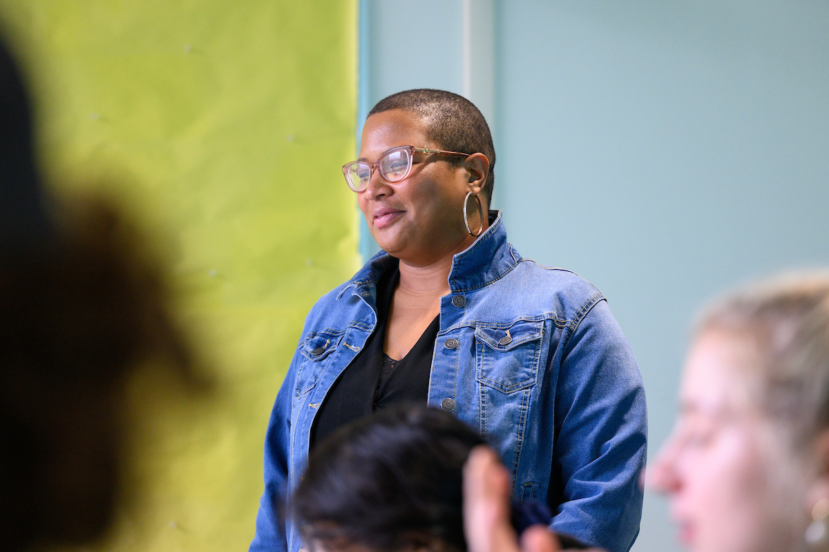 female professor in denim jacket, glasses, and short hair