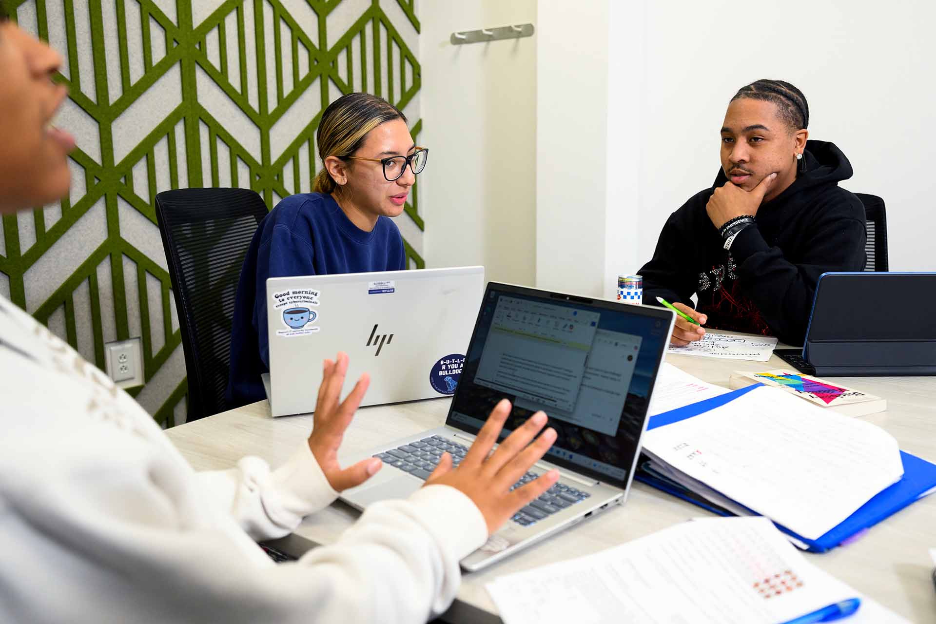 Three students from Founder's College work together at a group study table.