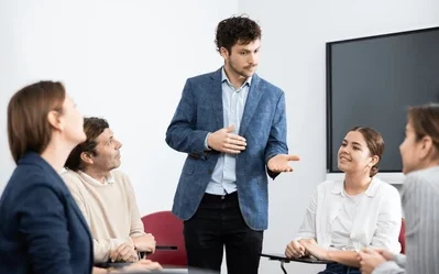 Several people together, with one person talking in the middle of the group of people