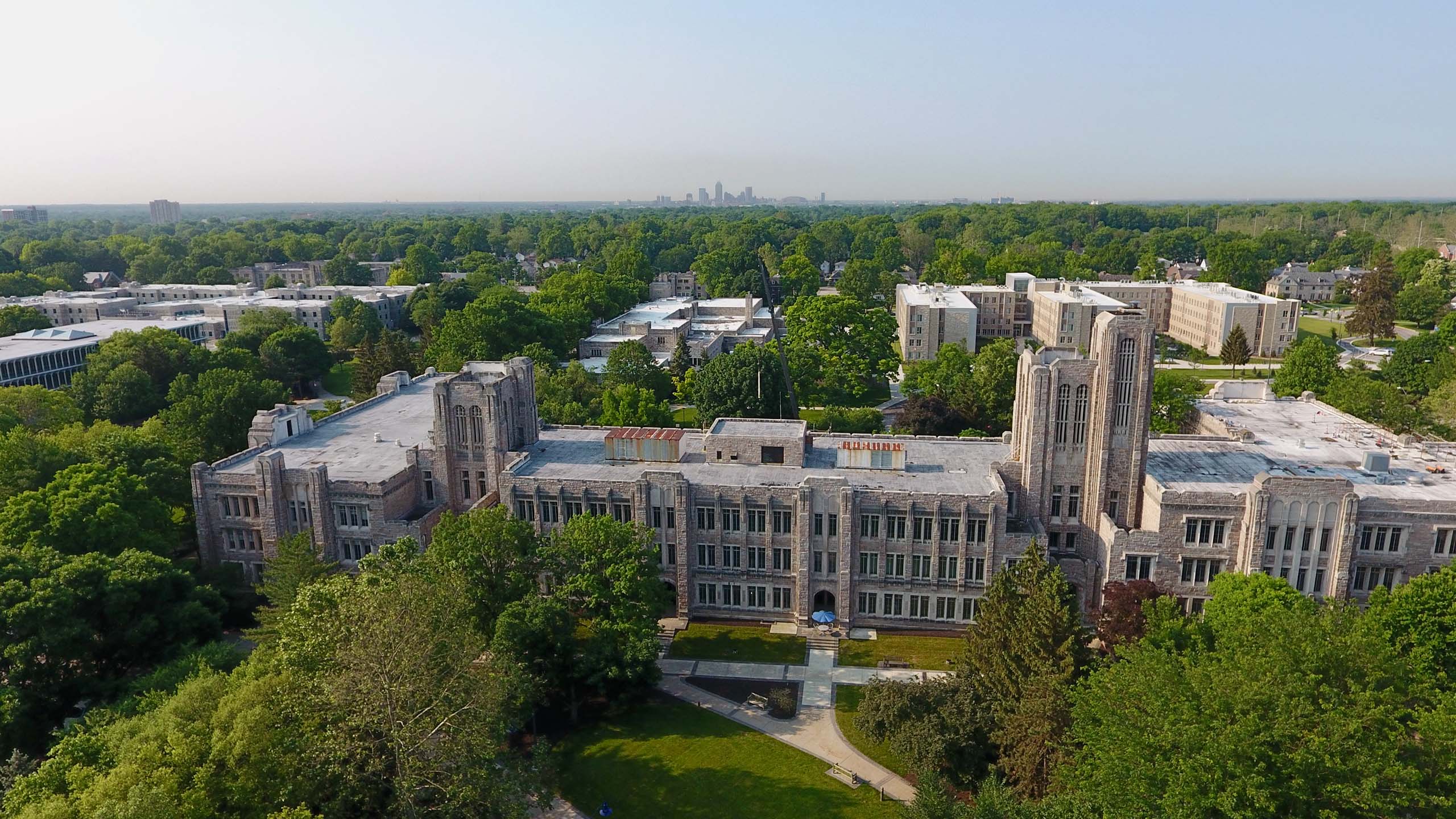 Aerial view of Jordan Hall and college campus with Downtown Indianapolis skyline in background.