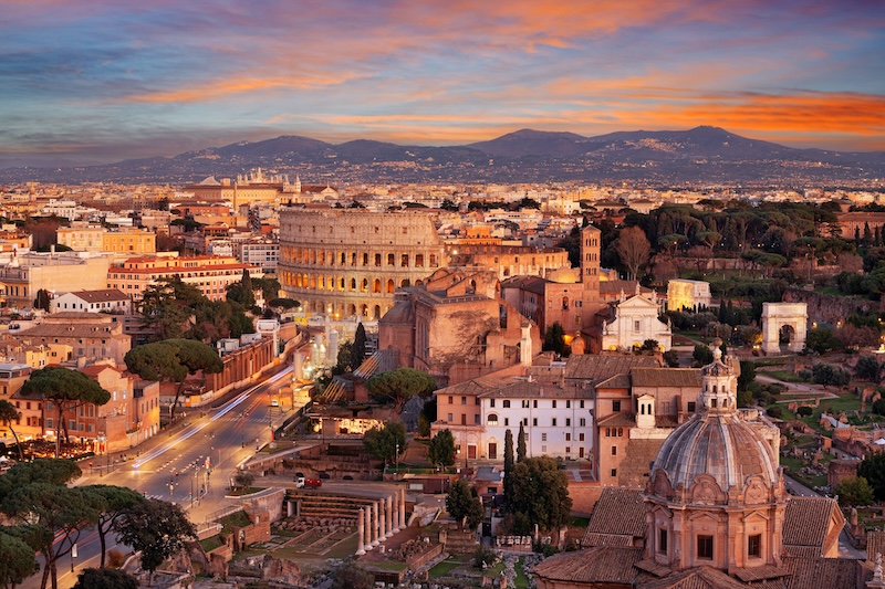 Evening sunset view of ancient buildings like the Colosseum in Rome, Italy.
